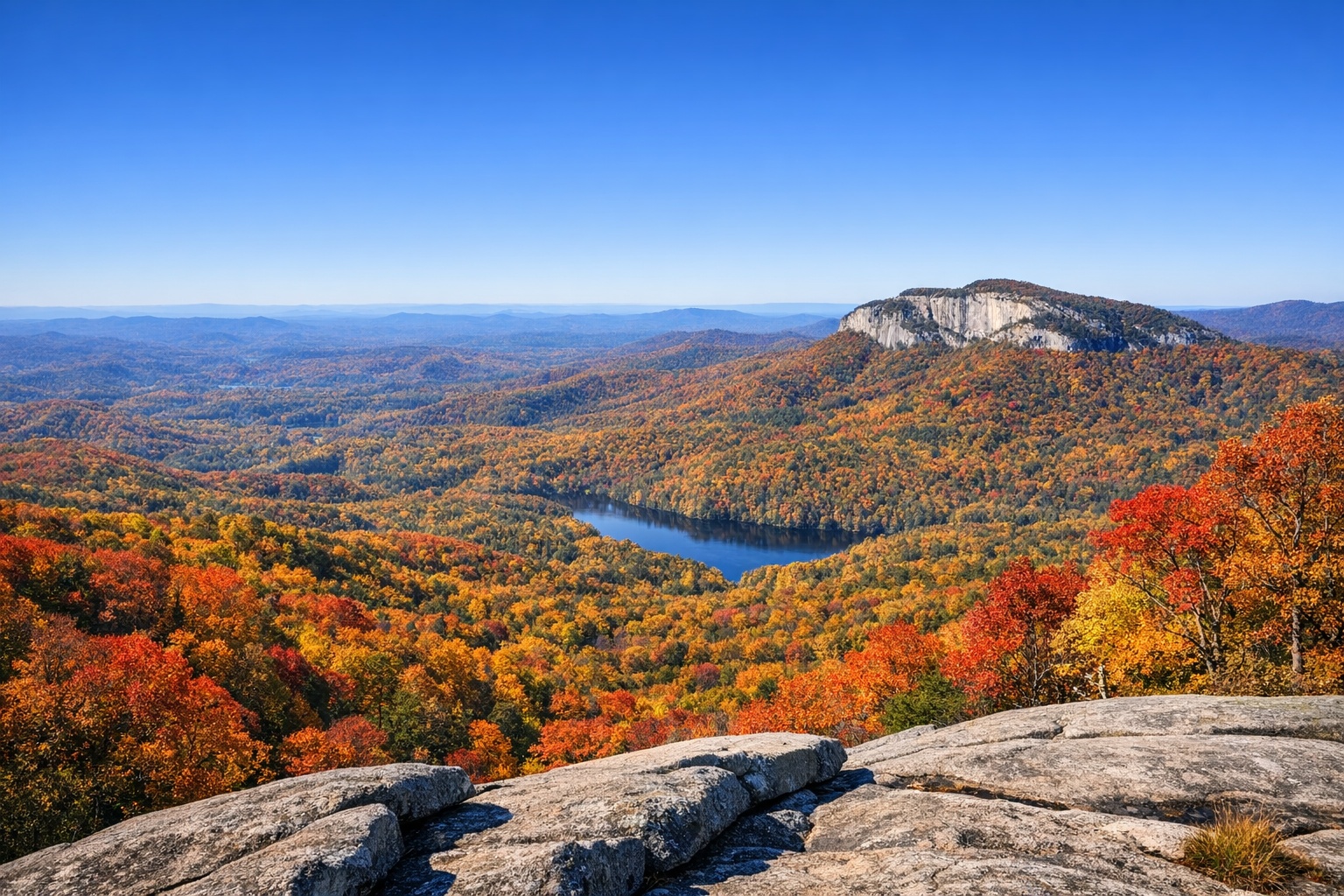 Table Rock State Park South Carolina breathtaking autumn foliage view from mountain summit with red orange yellow trees and blue sky